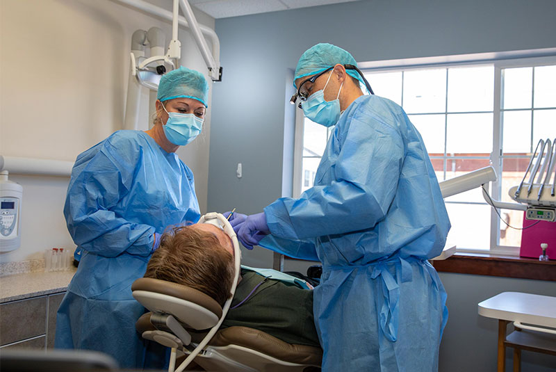 doctors performing dental procedure with patient within the dental practice
